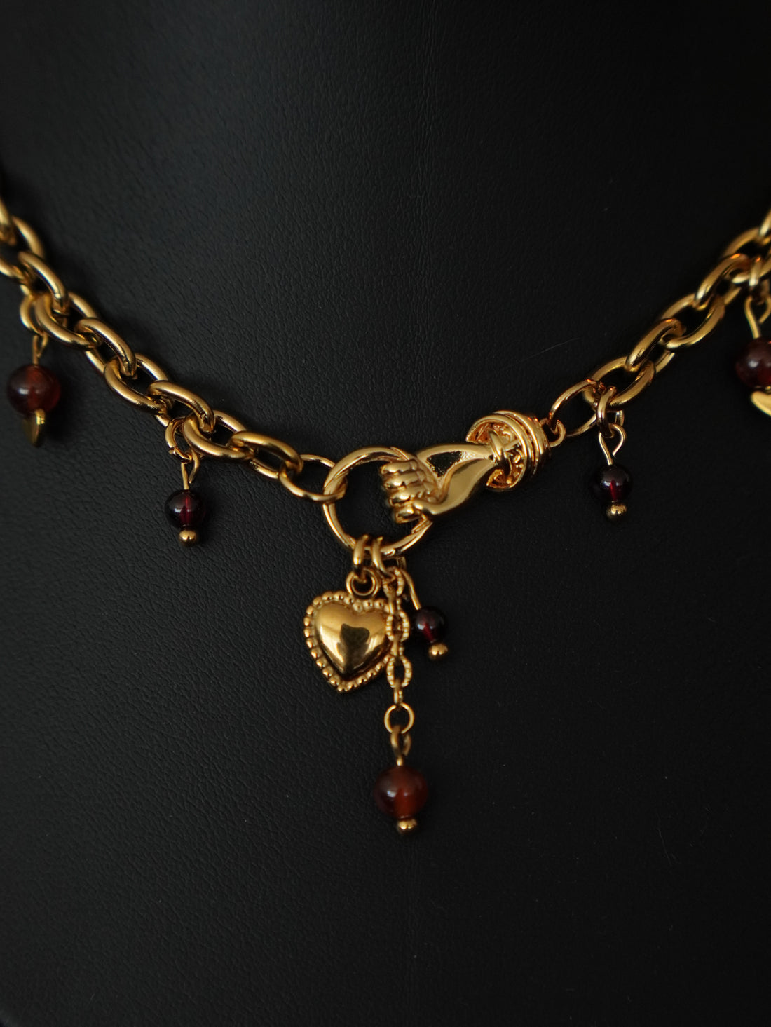 détail collier doré et perles de grenat style alternatif 