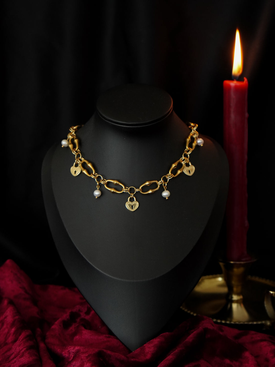 collier style gothique sur fond noir et rouge ambiance tamisée 